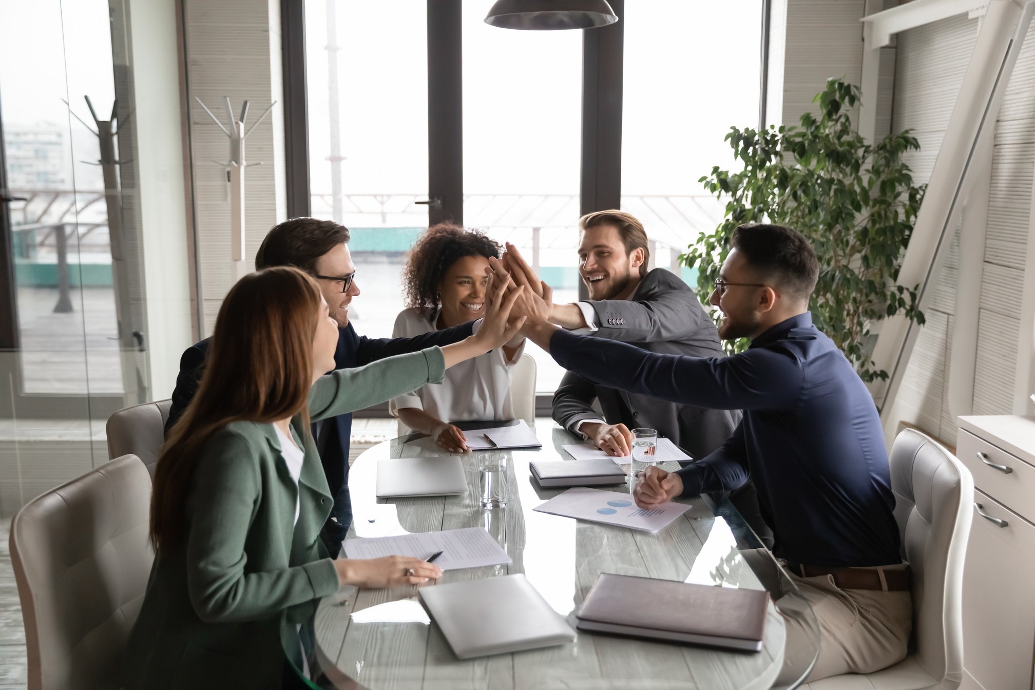 Excited diverse employees engaged in teambuilding activity at meeting